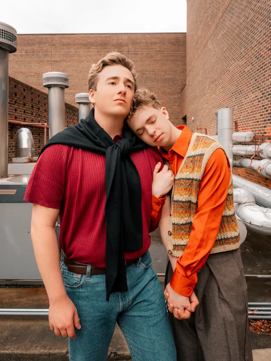 The two brothers, Nikolas and Elias, lean together on a rooftop.