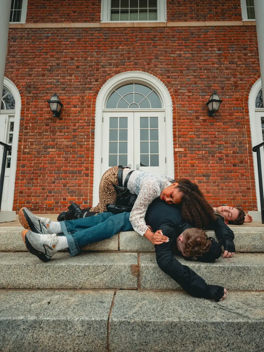 Tig lies grieving across the bodies of the fallen brothers on the town-hall steps.